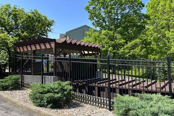 a gazebo in front of a fence with trees in the background  at The Vinings Apartments, Ohio